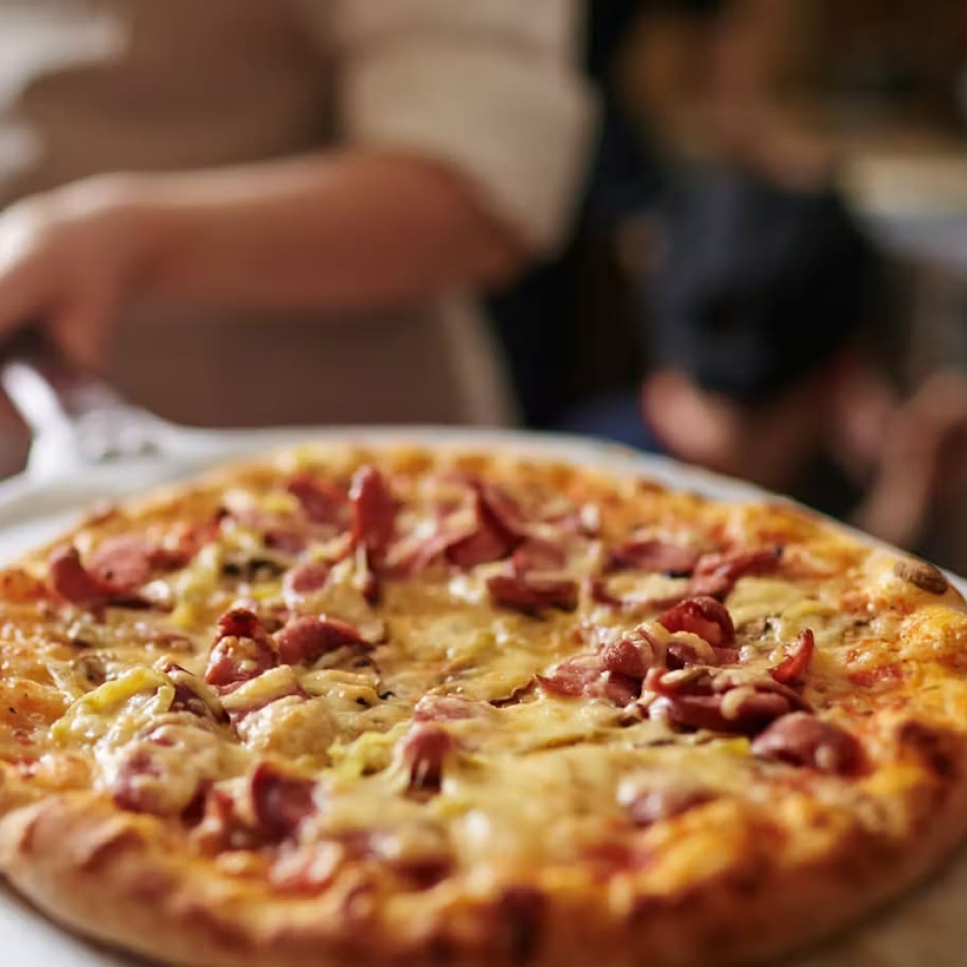 Pizza recién salida del horno siendo servida en iPizza & Burger Valladolid