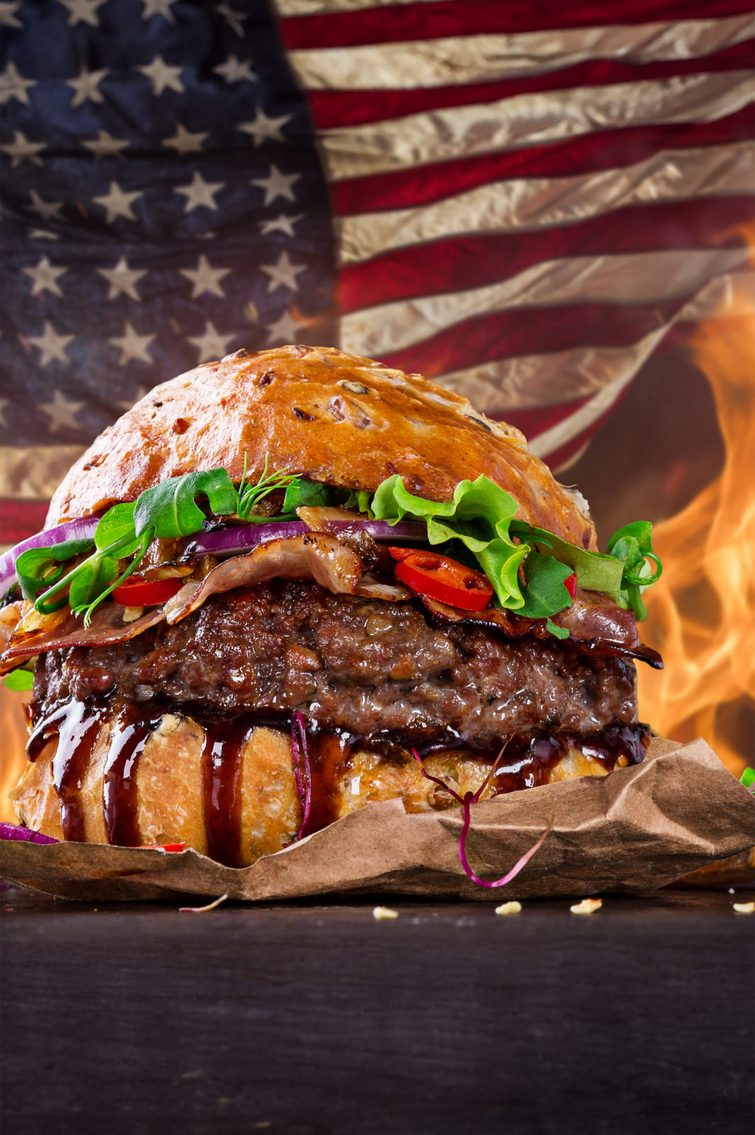 Hamburguesa americana con salsa BBQ frente a una bandera de Estados Unidos en iPizza & Burger Valladolid